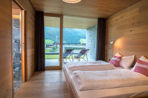two beds in a room with a view of a balcony at Smaragdresort in Bramberg am Wildkogel