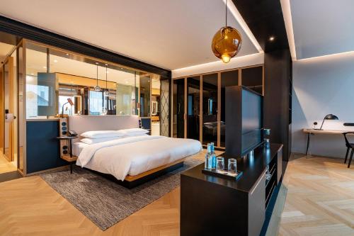 ein Schlafzimmer mit einem Bett und einem Flachbildfernseher in der Unterkunft Andaz Munich Schwabinger Tor, By Hyatt in München