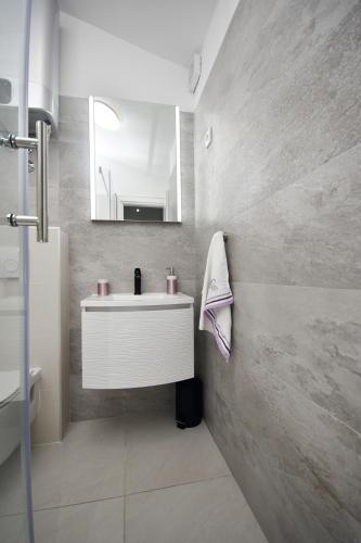 a bathroom with a white sink and a mirror at Relax House Kanica in Zaglavice