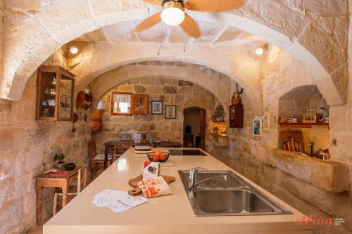 cocina con fregadero y ventilador de techo en Matli Farmhouse, your stunning Gozo getaway., en Munxar