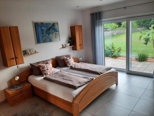 - une chambre avec un lit et une grande fenêtre dans l'établissement Villa Laffenau, à Heideck