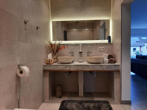 a bathroom with two sinks and a mirror at Villa Laffenau in Heideck