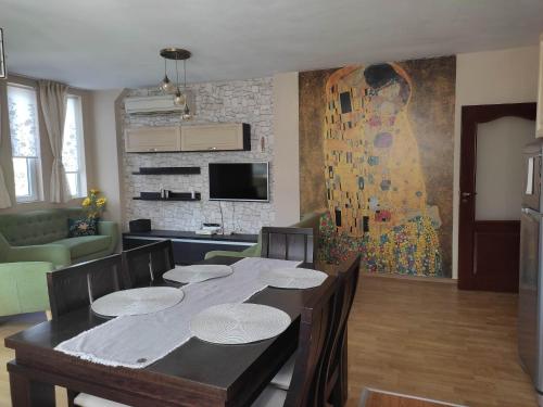 Sliven的住宿－Apartment Ventuno 21，用餐室配有桌椅和绘画作品