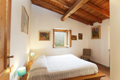 1 dormitorio con cama y ventana. en I due Ghiri en Calice al Cornoviglio