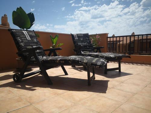 two chairs sitting on top of a balcony at Marina de Casares Suites in San Luis de Sabinillas
