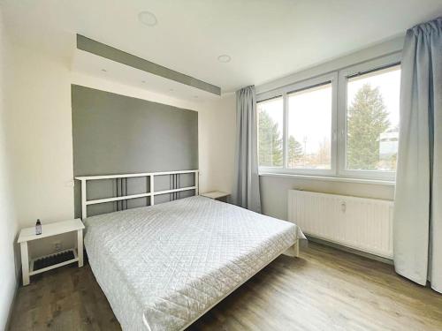 una camera con un letto bianco e due finestre di Krásný zrekonstruovaný byt 3+1 a Liberec