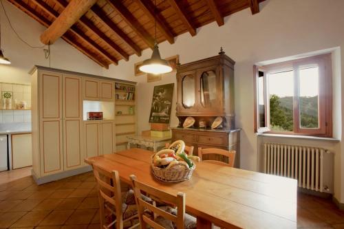 a kitchen with a wooden table with a basket of fruit at I due Ghiri in Calice al Cornoviglio
