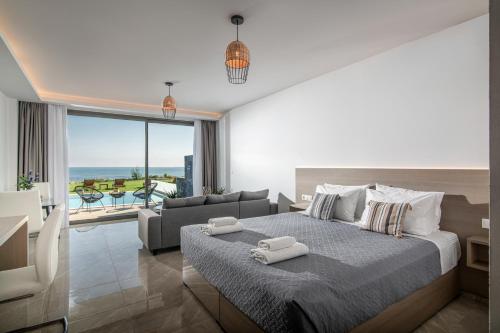 een slaapkamer met een bed en een woonkamer bij Crete Resort Sea Side Suites "Adults Only" by Checkin in Gouves