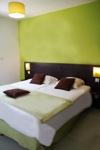 une chambre avec un grand lit avec un mur végétal dans l'établissement Le Clos Du Champ De L'amour, à Saint-Simon-de-Bordes