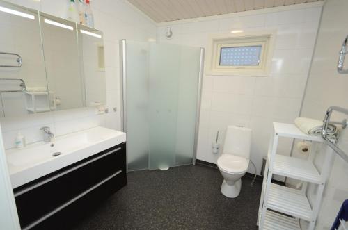 La salle de bains blanche est pourvue d'un lavabo et de toilettes. dans l'établissement Ekkerøy Feriehus, à Vadsø