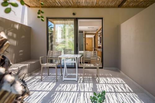 a room with a table and chairs on a patio at Stella Village Seaside Hotel in Hersonissos