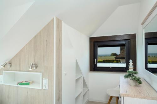 a room with a staircase with a desk and a window at Haus Humml in Grömitz