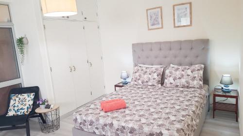 a bedroom with a bed with an orange pillow on it at Reis Turismo in Faro