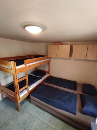 a room with three bunk beds and a light at Chata Adam in Patince
