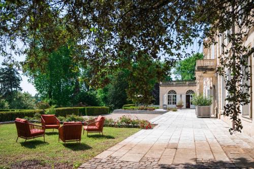a group of chairs sitting in the grass next to a building at Château de Lussac in Lussac