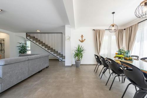 a living room with a couch and a table and chairs at Villa Molaris ZadarVillas in Donje Selo