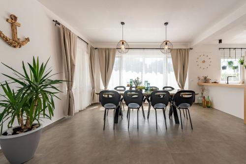 a dining room with a table and black chairs at Villa Molaris ZadarVillas in Donje Selo