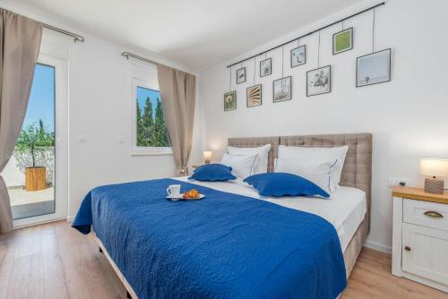 ein Schlafzimmer mit einem blauen Bett und einem Tablett mit Essen darauf in der Unterkunft Villa Molaris in Donje Selo
