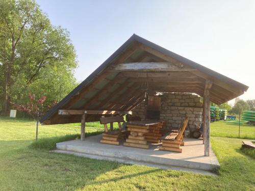 ein Gebäude mit einem Stapel Holz auf einem Feld in der Unterkunft Leśne zacisze-pole namiotowe in Pisklaki