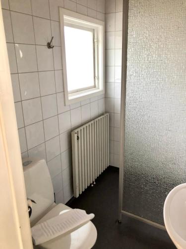 a bathroom with a toilet and a window and a sink at Vätterledens Stugrum in Gränna