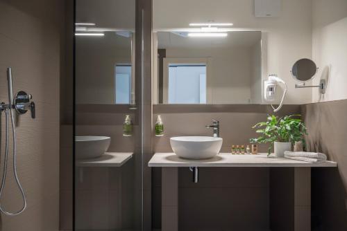 a bathroom with two sinks and a mirror at Hotel Giardino Suites&Spa in Numana