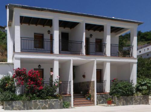 una casa blanca con balcones encima en CASASBLANCAS, Casa nr 2 en Mecina Bombarón