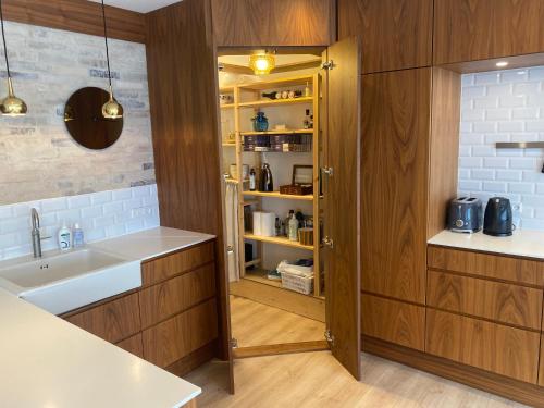 a kitchen with wooden cabinets and a sink at Aalborg - Beautifully renovated luxus apartment in Aalborg