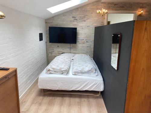 a small bedroom with a bed and a mirror at Aalborg - Beautifully renovated luxus apartment in Aalborg