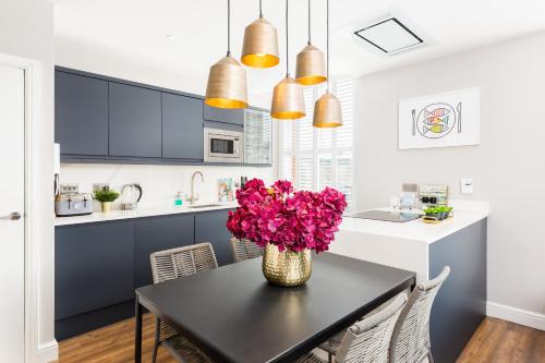 a kitchen with a black table with flowers on it at The Shirt Factory Apartments in Warrington