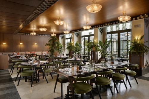 a dining room with tables and chairs and chandeliers at Stradom House, Autograph Collection in Krakow