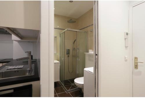 une salle de bain avec une douche, des toilettes et un lavabo dans l'établissement Paris Cosy Apartment Opéra Vendome Galeries Lafayette, à Paris