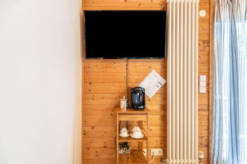 a room with a wall with a tv and a shelf at Höri-glück in Öhningen