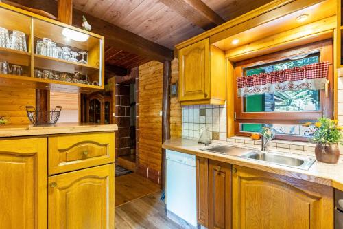 uma cozinha com armários de madeira, um lavatório e uma janela em Blockhaus Günther und Brigitte Serr em Lauf