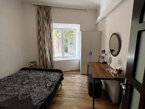 um quarto com uma cama, uma secretária e uma janela em beautiful apartment near opera in t'bilisi center em Tbilisi