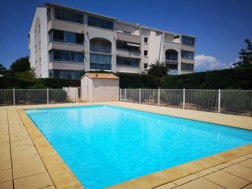 une grande piscine bleue devant un immeuble dans l'établissement Appartement avec piscine et garage proche plage et commerces, à La Seyne-sur-Mer