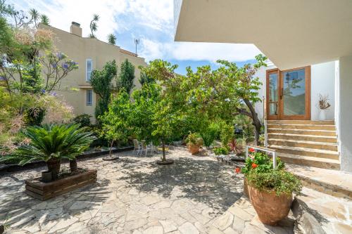 a courtyard with trees and plants in front of a house at Hauzify I Villa del Castell in Altafulla