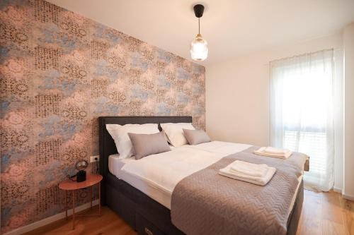 Un dormitorio con una cama grande con una pared de acento floral en Apartments Mila M, en Sveti Filip i Jakov