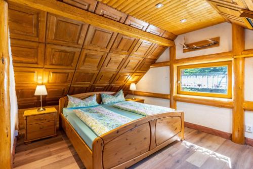 Łóżko w pokoju z drewnianym sufitem w obiekcie Blockhaus Günther und Brigitte Serr w mieście Lauf