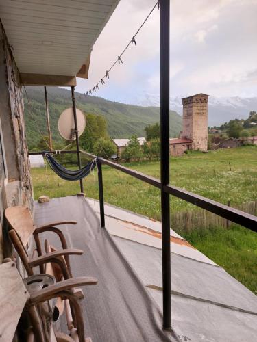 a porch with chairs and a view of a field at Bombora in Mestia