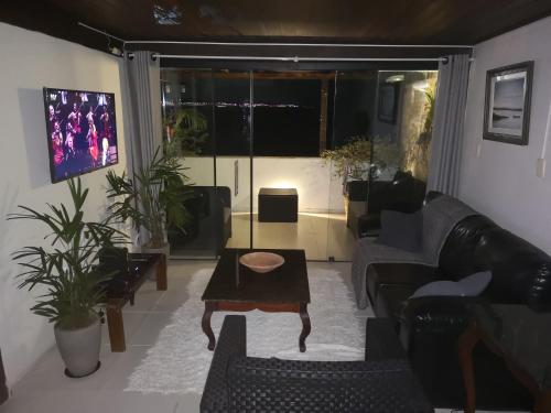 uma sala de estar com um sofá e uma mesa em Coco Beach em Natal