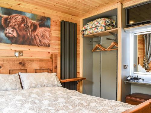a bedroom with a bed and a picture of a cow on the wall at The Hollies in Tansley