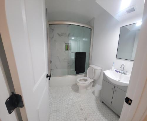 a white bathroom with a toilet and a sink at The Kickback! in Washington, D.C.