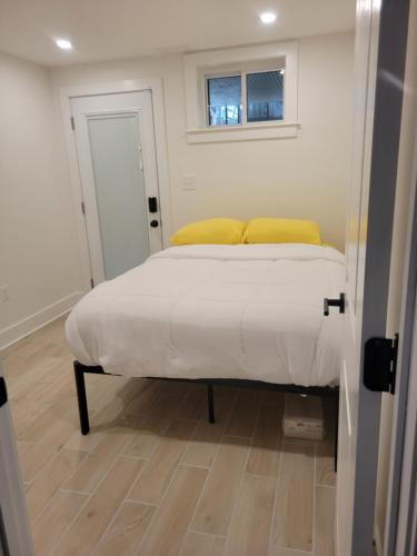 Un dormitorio con una cama con almohadas amarillas y una ventana en The Kickback!, en Washington