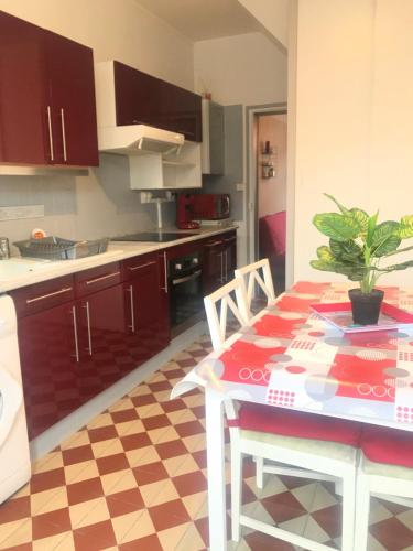 una cocina con una mesa con una maceta. en La maisonnée de Chambord, en Crouy-sur-Cosson