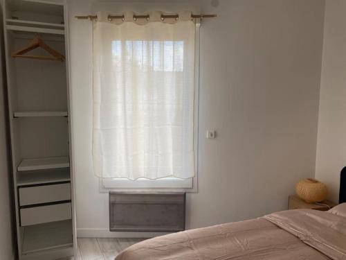 une chambre avec une fenêtre avec un rideau et un placard dans l'établissement Appartement 1 chambre proche gare de Bordeaux, à Bordeaux