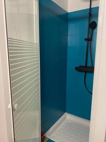 La salle de bains est pourvue d'une douche avec un mur bleu. dans l'établissement Appartement 1 chambre proche gare de Bordeaux, à Bordeaux