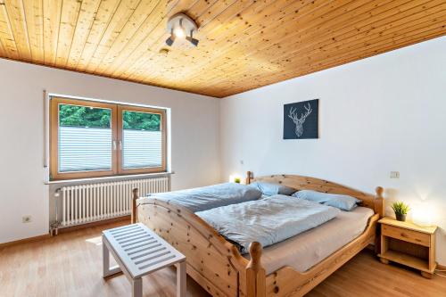 a bedroom with a bed with a wooden ceiling at Haus Weber in Hölzberg