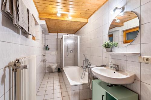 ein Badezimmer mit einem Waschbecken, einem WC und einer Badewanne in der Unterkunft Haus Weber in Hölzberg