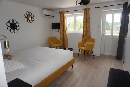 1 Schlafzimmer mit einem Bett und 2 Stühlen in der Unterkunft Riva Studio in Saint-Aignan