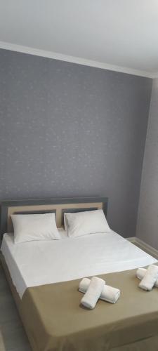 a bed with two white towels on top of it at Gabala rent House in Gabala